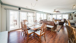 A spacious living room with a dining area, large windows, and a ceiling fan. - Riverfront hidden gem, ground floor open space! (Madison Heights)