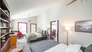 A spacious bedroom with two beds, a wooden bookshelf, a desk, and a chair. - Riverfront hidden gem, ground floor open space! (Madison Heights)
