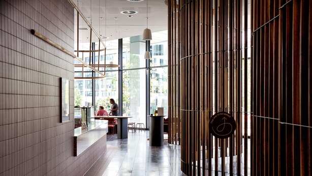 Un intérieur moderne avec un comptoir d’accueil, de grandes fenêtres et un mur en bambou.
