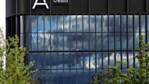 Un bâtiment moderne doté d’une grande façade en verre, d’un logo en forme de « A » bien visible et d’une enseigne indiquant « Adina ».