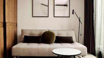 A modern living room with a sofa, two framed abstract artworks, a floor lamp, and a small table.