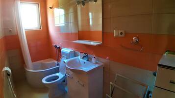 Un baño con inodoro, lavabo, espejo y bidé.