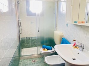A bathroom with a shower, toilet, bidet, and sink. - Comfy Seafront Apartment-beahost (San Michele al Tagliamento)
