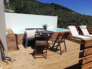 A wooden deck with a pool, lounge chairs, and a table with chairs. - 2br Suite White gea With Private Pool No01 (Skiathos)