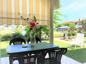Relax on the patio surrounded by lush greenery and a serene view.
