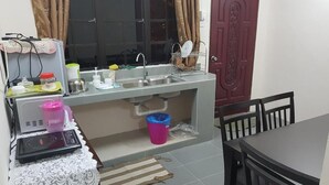 A compact kitchen with a sink, a microwave, and a small table. - Mri Homestay Sg Buloh - 2 Br House With Centralised Private Pool (Sungai Buloh)