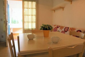 Un coin repas avec une table, des chaises et une plante en pot.