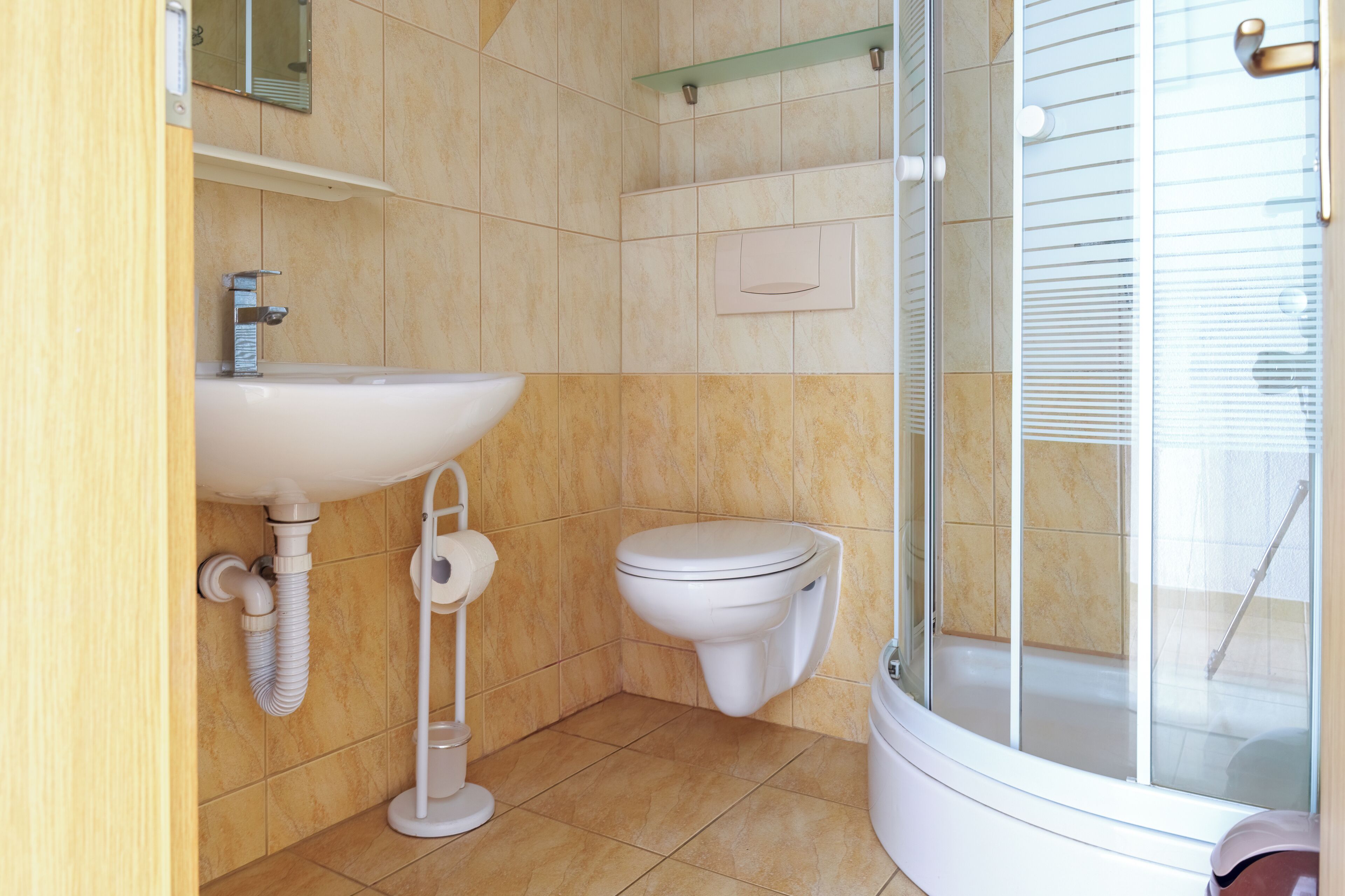 Ein Badezimmer mit Waschbecken, Toilette und einer Duschkabine aus Glas.