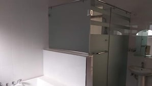Ein Badezimmer mit Duschkabine, weißer Badewanne und Waschbecken.