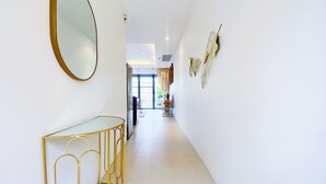 A hallway with a gold-framed mirror, a gold-framed console table, and wall-mounted decorative leaves. - Beautiful 1br Plunge Pool Villa Walk To Bangtao Beach (Choeng Thale)
