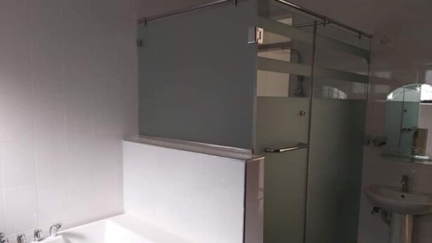 A bathroom with a glass-enclosed shower, a white bathtub, and a sink. - A Fully Furnished Apartment in Kampala (Kampala)