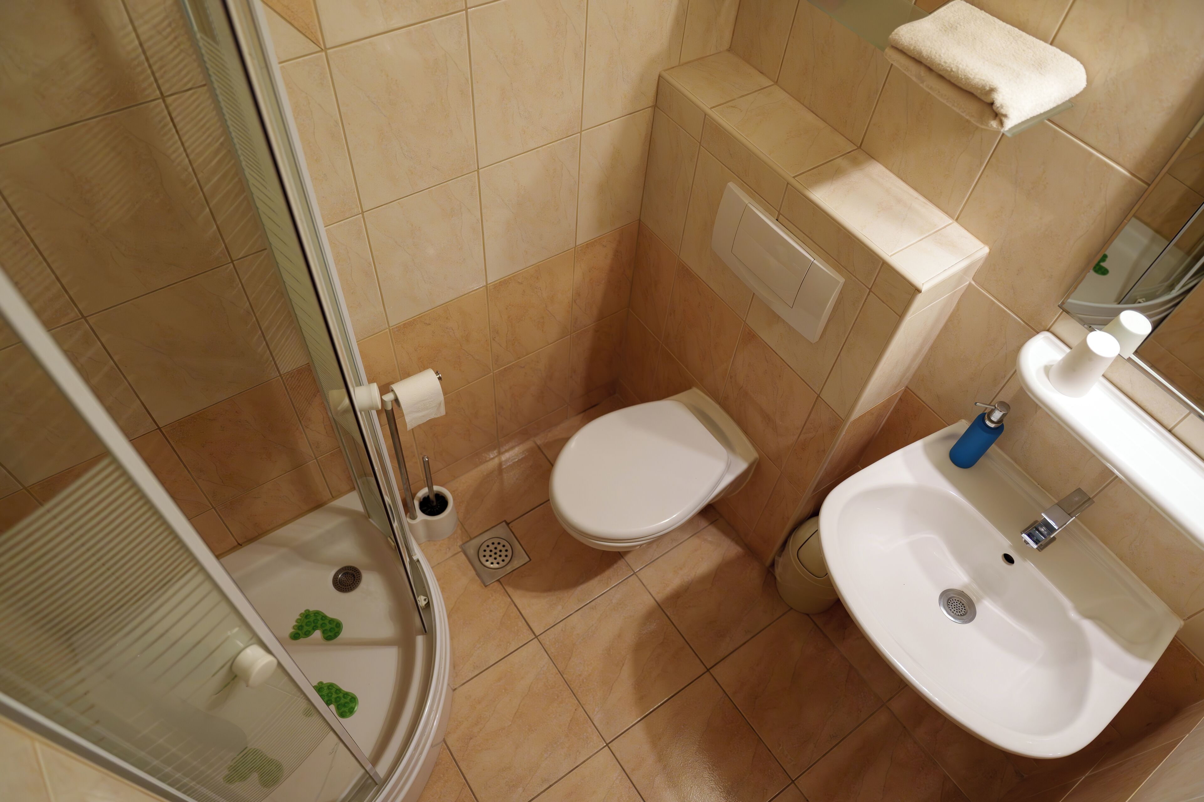 A bathroom with a toilet, sink, and shower.