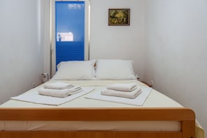 Cozy retreat with a single bed, framed picture, and neatly folded towels.