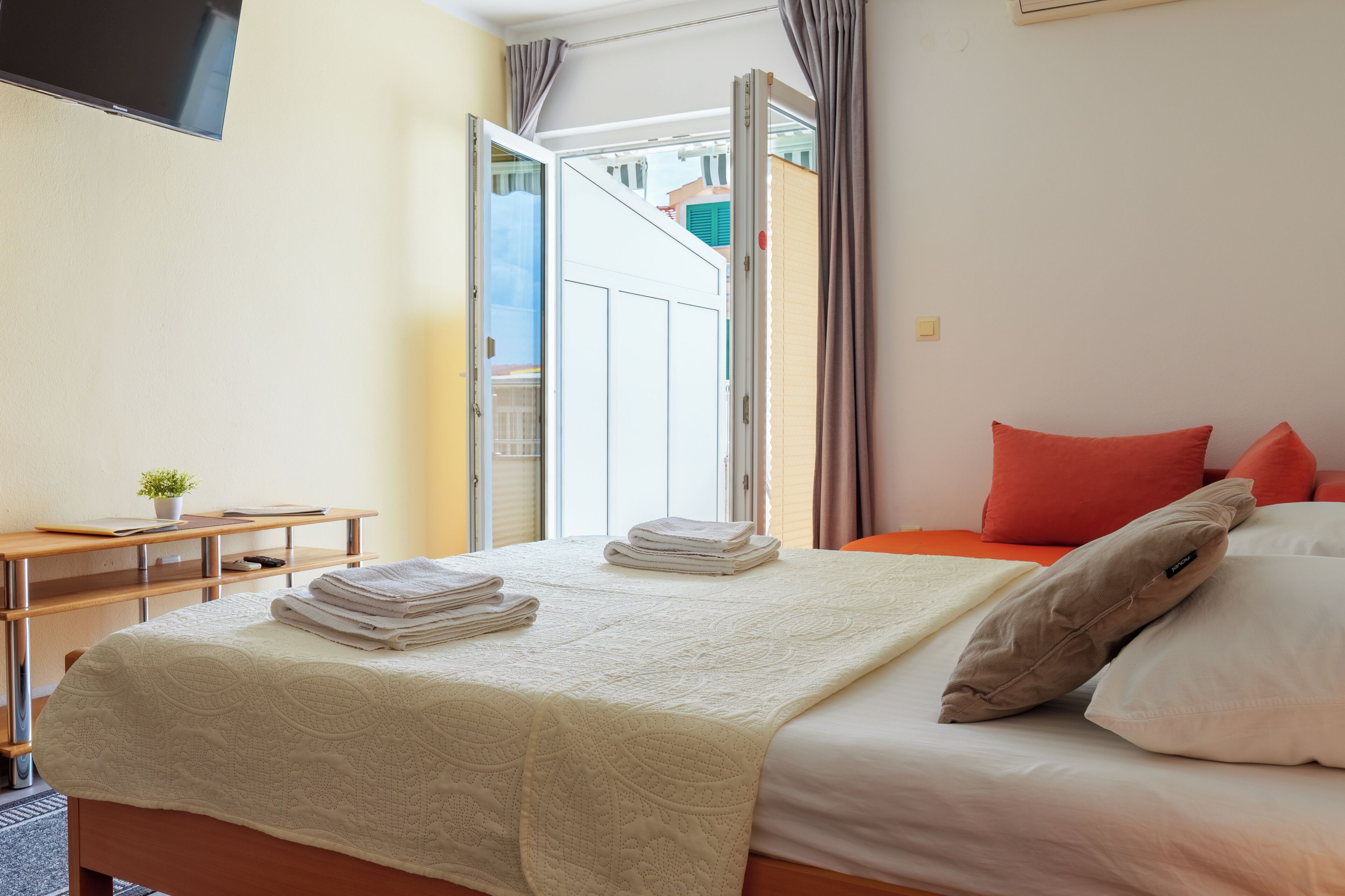 Ein Hotelzimmer mit Bett, Schreibtisch und Fernseher.
