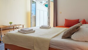 A hotel room with a bed, a desk, and a TV. - Studio With Sea View for 2-3people by the Water (Baska Voda)