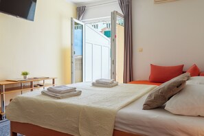 A hotel room with a bed, a desk, and a TV. - Studio With Sea View for 2-3people by the Water (Baska Voda)