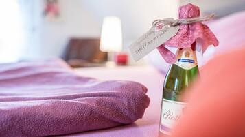 A bottle of wine with a tag, a purple towel, and a lamp in the background.