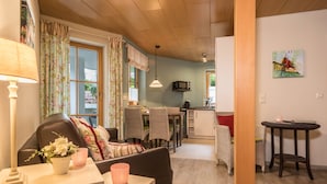 Una sala de estar acogedora con un sofá, una mesa de comedor y una cocina al fondo.