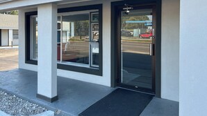 A building with a modern entrance featuring large glass doors and a black frame. - Motel 6 Ponca City, OK (Ponca City)