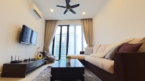 A modern living room with a sofa, coffee table, TV, and a ceiling fan.