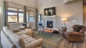 A spacious living room with a fireplace, a large TV mounted above it, and a cozy seating area with a sofa and armchair. - Ski & Hike: Home w/ Hot Tub + Gas Grill in Granby (Granby)