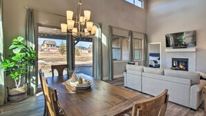 A spacious living room with a wooden dining table, a gray sofa, and a fireplace. - Ski & Hike: Home w/ Hot Tub + Gas Grill in Granby (Granby)