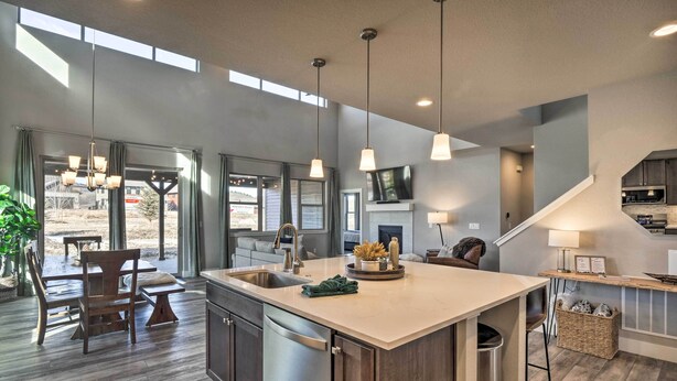 A modern kitchen with a large island, pendant lighting, and a view of the outdoors. - Ski & Hike: Home w/ Hot Tub + Gas Grill in Granby (Granby)