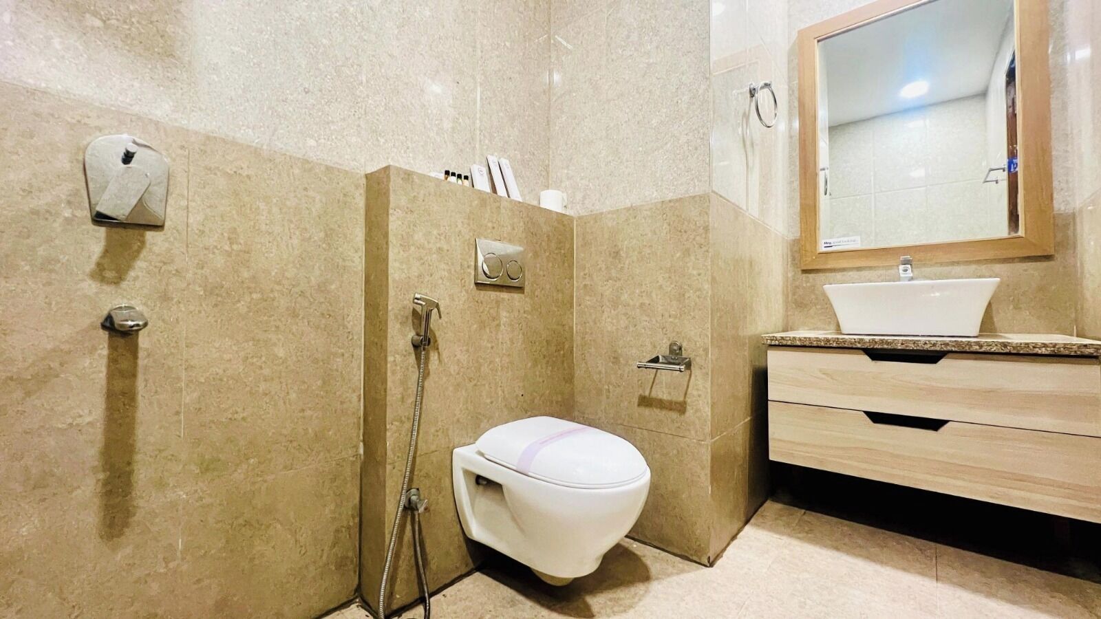 A modern bathroom with a white toilet, a shower, and a sink with a mirror above it.