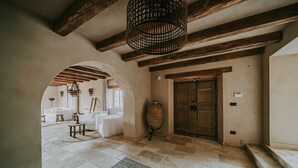 A spacious interior with a high ceiling, exposed wooden beams, a large vase, and a white sofa. - Luxury estate with 60.000 sqm land near hilltop town Motovun (Motovun)