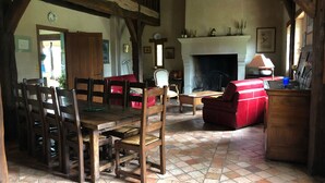 Une pièce de style traditionnel, dotée d’une cheminée, de meubles en bois et d’un sol carrelé.