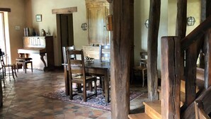 Un coin repas au style rustique, avec des meubles en bois, un sol carrelé et des poutres apparentes.