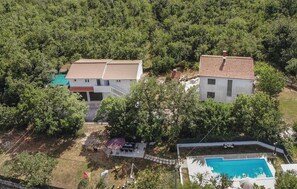 Un quartier résidentiel comprenant deux maisons, une piscine et un patio couvert.
