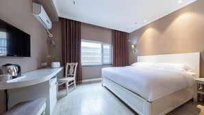 A hotel room with a bed, a desk with a chair, a TV, and a window with curtains. - Jinyi Hotel (Runyu store of Hohhot University of Technology) (Hohhot)
