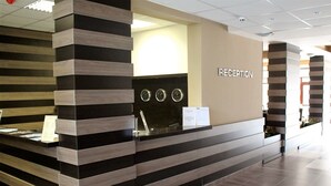 A reception desk with a modern design, featuring a striped pattern and a clock above it. - Borovets Green Hotel (Samokov)