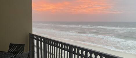 Ein Balkon mit Blick auf das Meer bei Sonnenuntergang.