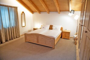 Un dormitorio con cama de madera, mesitas de noche, un espejo y un armario.