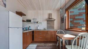 Una cucina con mobili in legno, un frigorifero bianco, un forno a microonde e una finestra con vista.