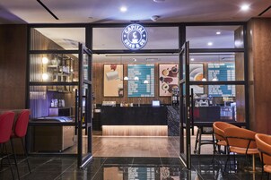 A modern coffee shop interior with a reception desk, seating area, and menu boards.