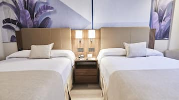 A hotel room with two beds, a wooden nightstand, and a wall-mounted lamp.