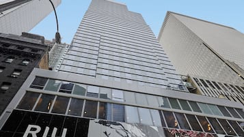 Un rascacielos con un cartel grande que anuncia el Hotel Manhattan Times Square.