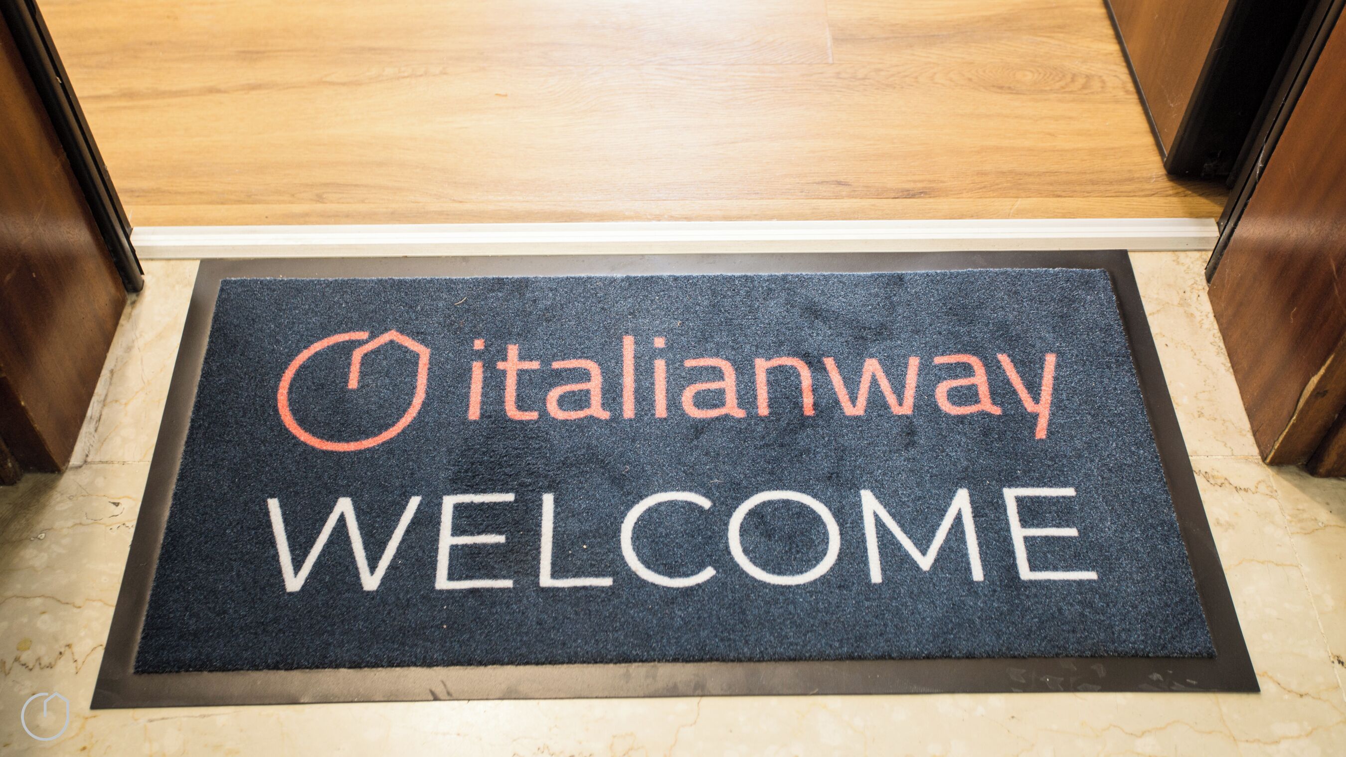 A doormat with the words "italianway" and "WELCOME" in white and orange letters.