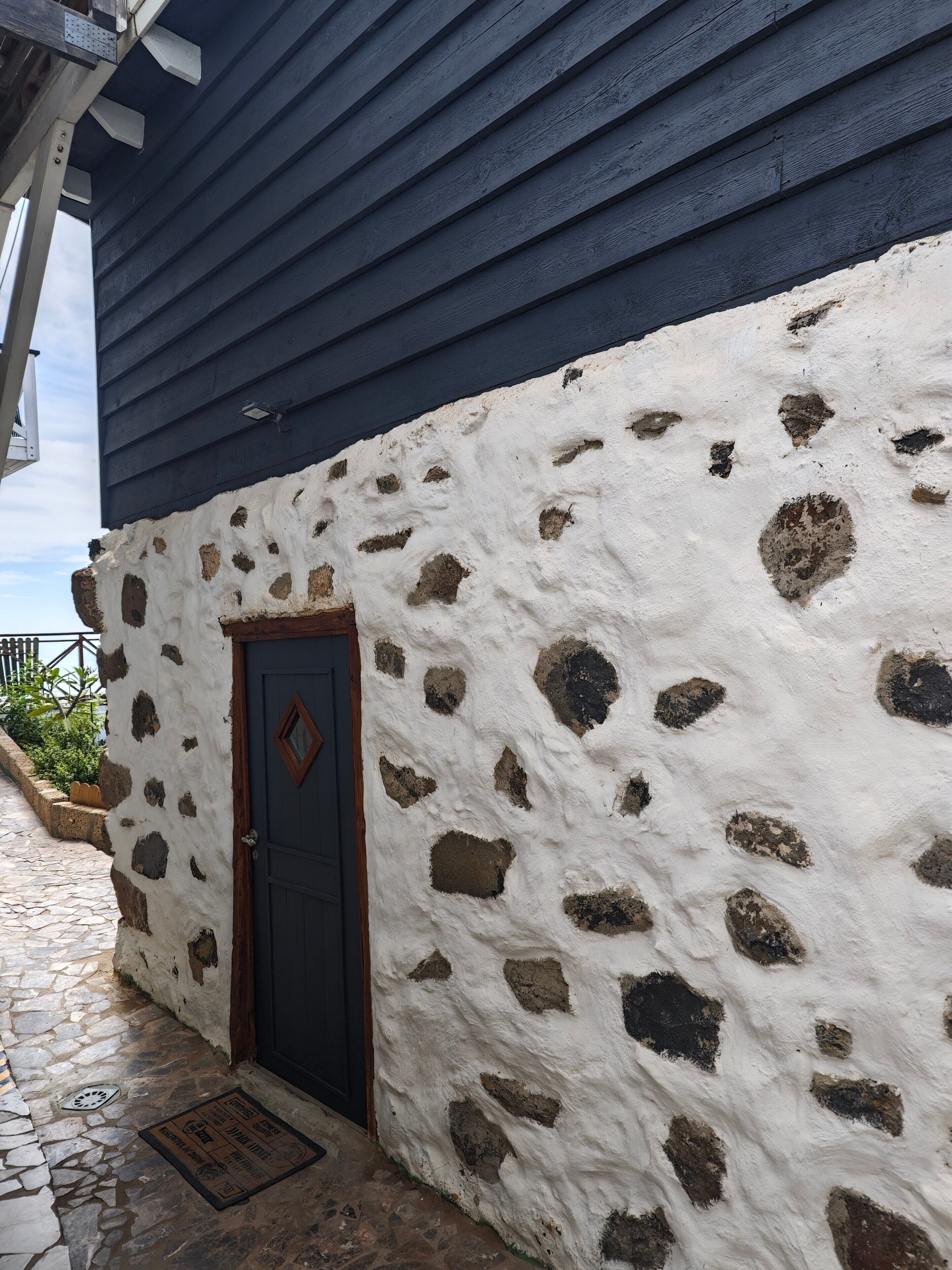 Een gebouw met een stenen gevel en een donkerblauwe dak.