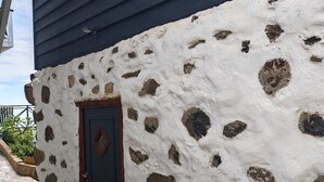 Un bâtiment à la façade en pierre et au toit bleu foncé.