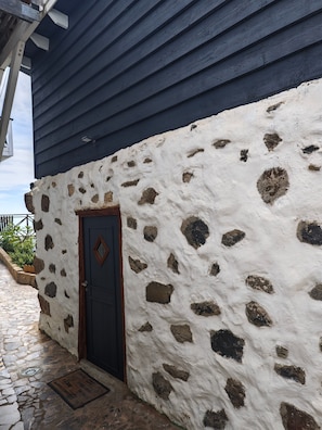 Un bâtiment à la façade en pierre et au toit bleu foncé.