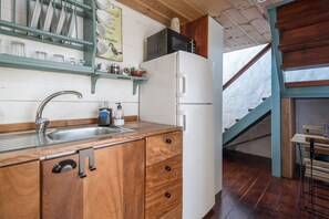 Une cuisine avec des meubles en bois, un réfrigérateur blanc, un four à micro-ondes et un évier.