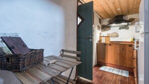 Une cuisine compacte avec des meubles en bois, une cuisinière encastrée et un petit coin repas comprenant une table et des chaises.