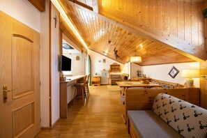 A wooden interior with a dining area, kitchen, and seating.