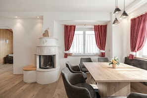 A modern kitchen with a built-in stove, a dining area with a wooden table and chairs, and a fireplace.