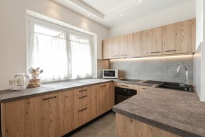 Una cocina moderna con armarios de madera, un microondas y un lavamanos.