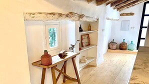 Een rustieke kamer met een houten tafel, planken en een raam.